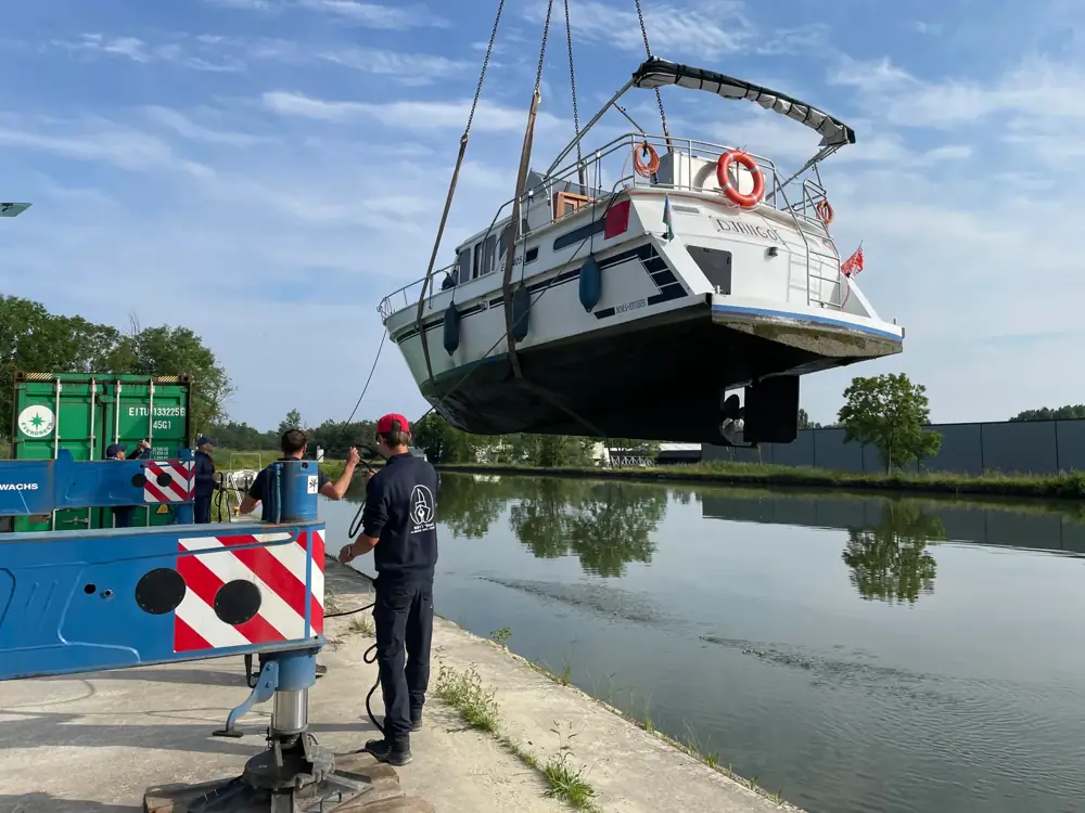 Un bateau soulevé par une grue sur le site de Dettwiller