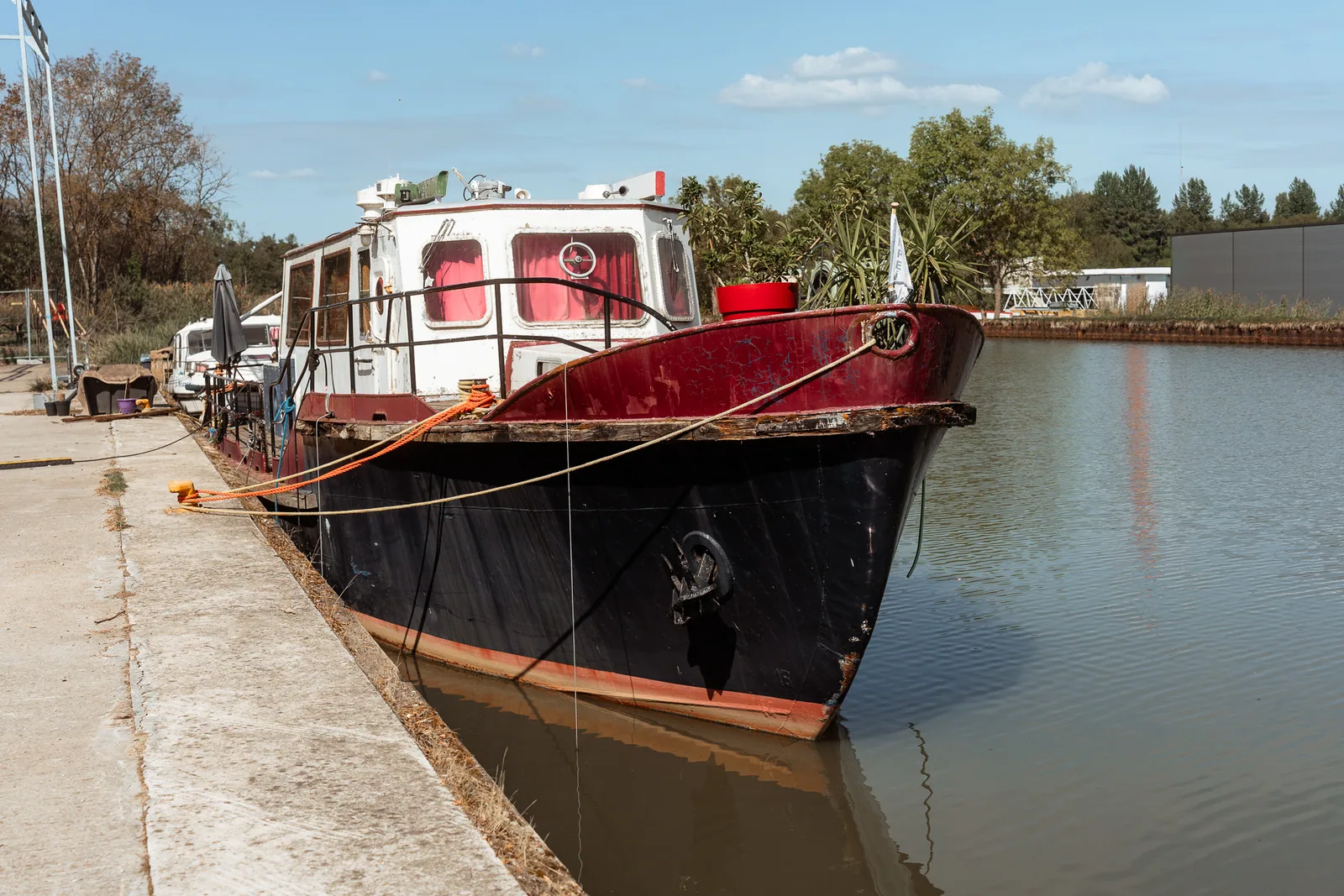 Bateau fluvial rouge et noir amarré à Dettwiller